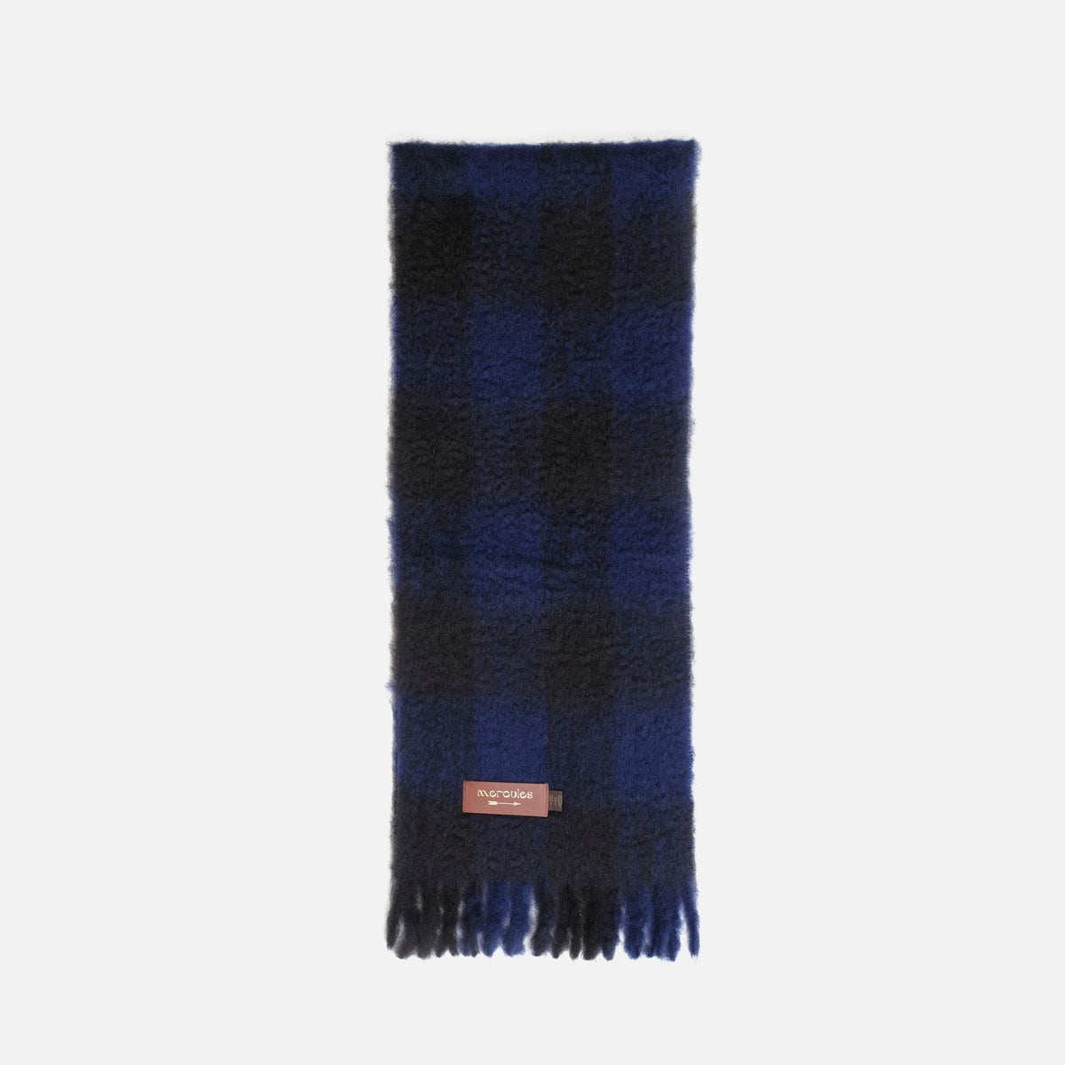 Bufanda de mohair de cuadros azul y negro: detalle de la textura, los flecos y la etiqueta Mercules