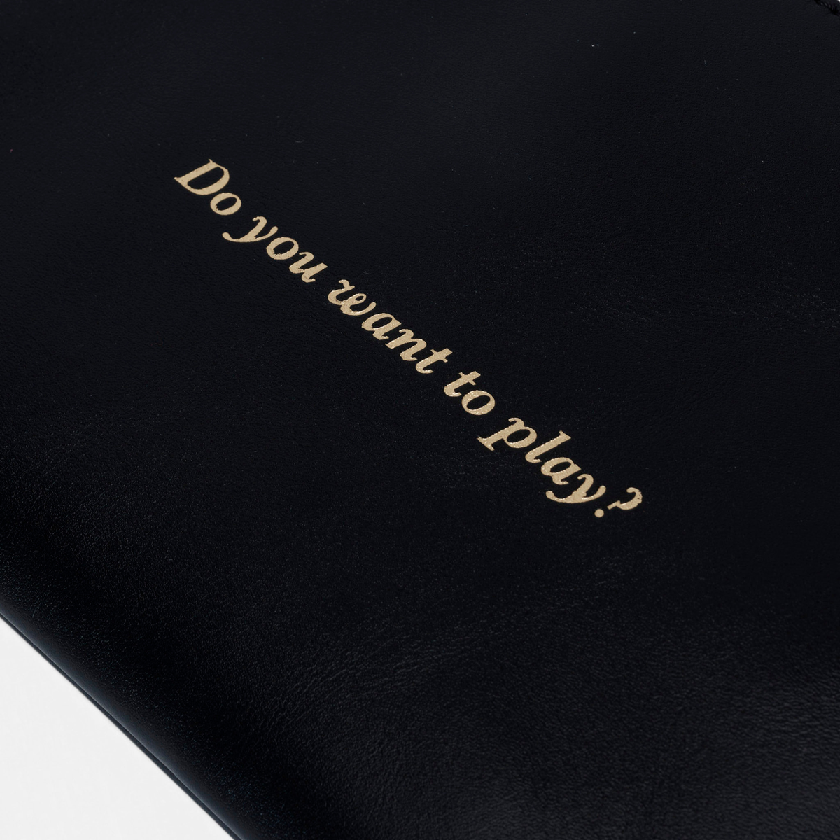 Zipper Play Negro de Mercules – clutch de piel negra con "Do you want to play?", vista 3